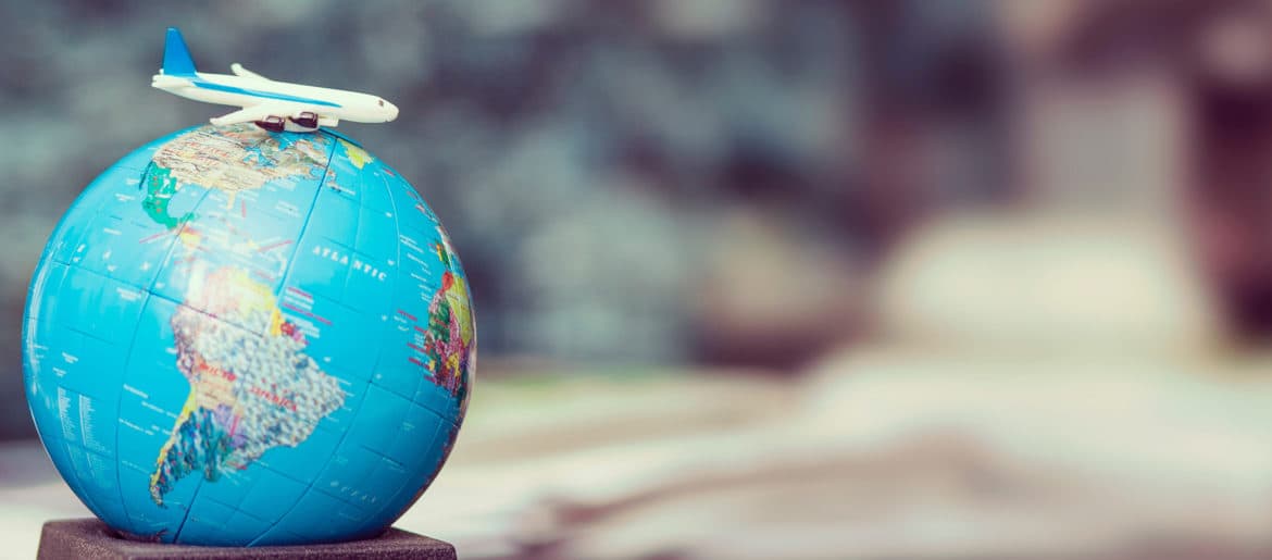a toy airplane is sitting on top of a globe.