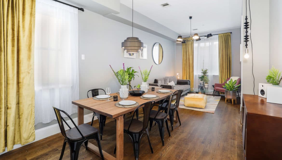 A dining room with a wooden Aleph table surrounded by chairs.