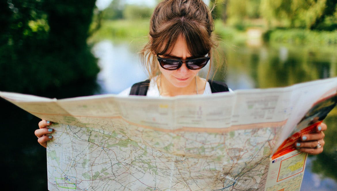 a woman in sunglasses looking at a map.