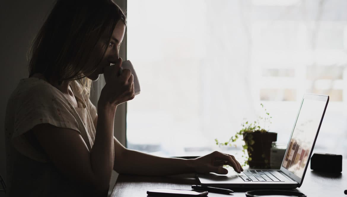 A woman engaged in remote work with a laptop.