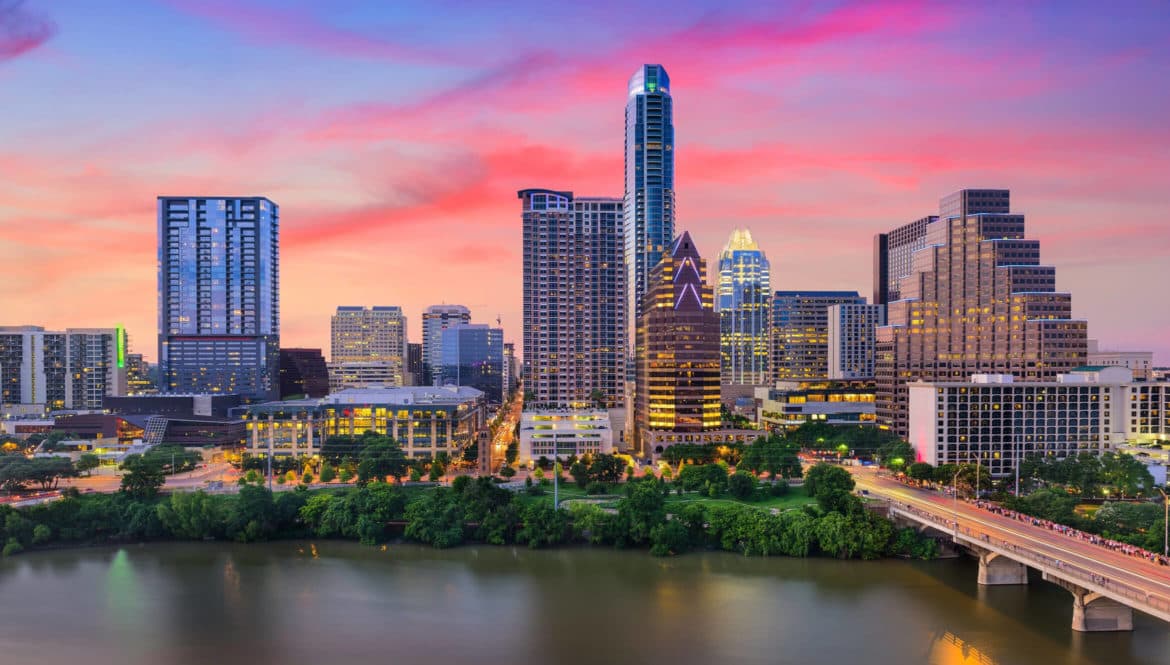 a city skyline with a bridge over a river.