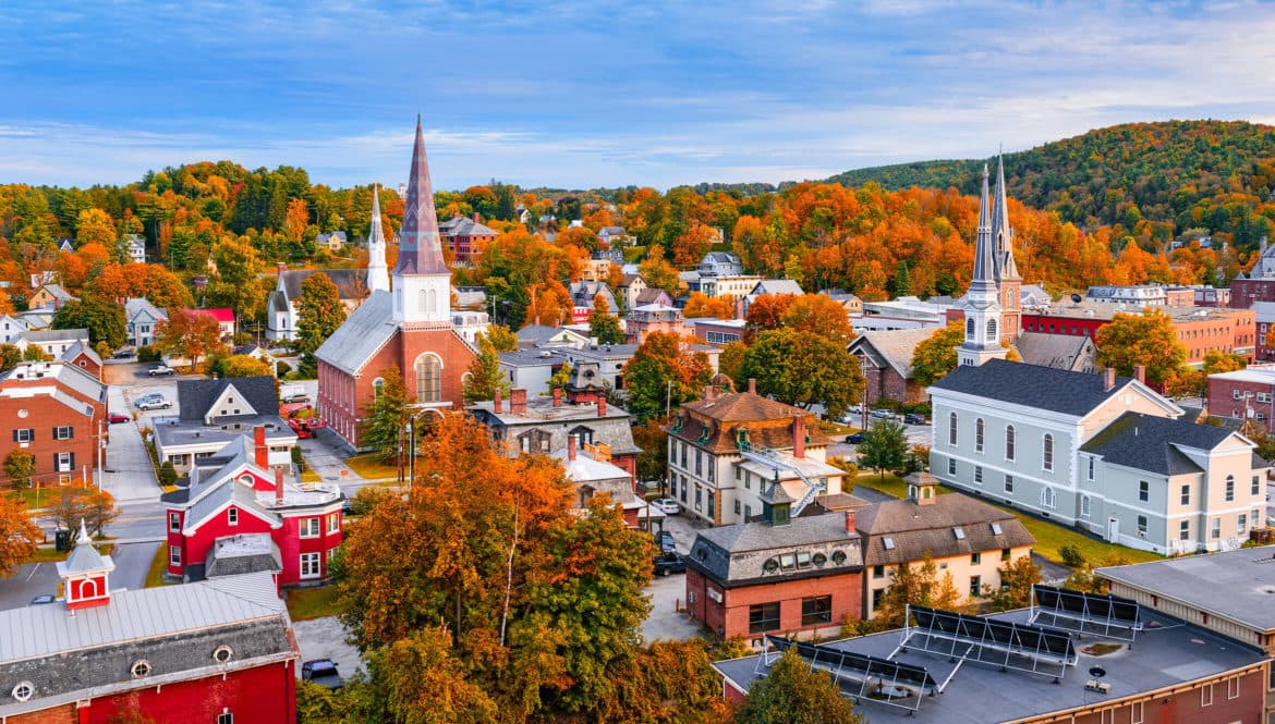 a small town with a steeple in the background.