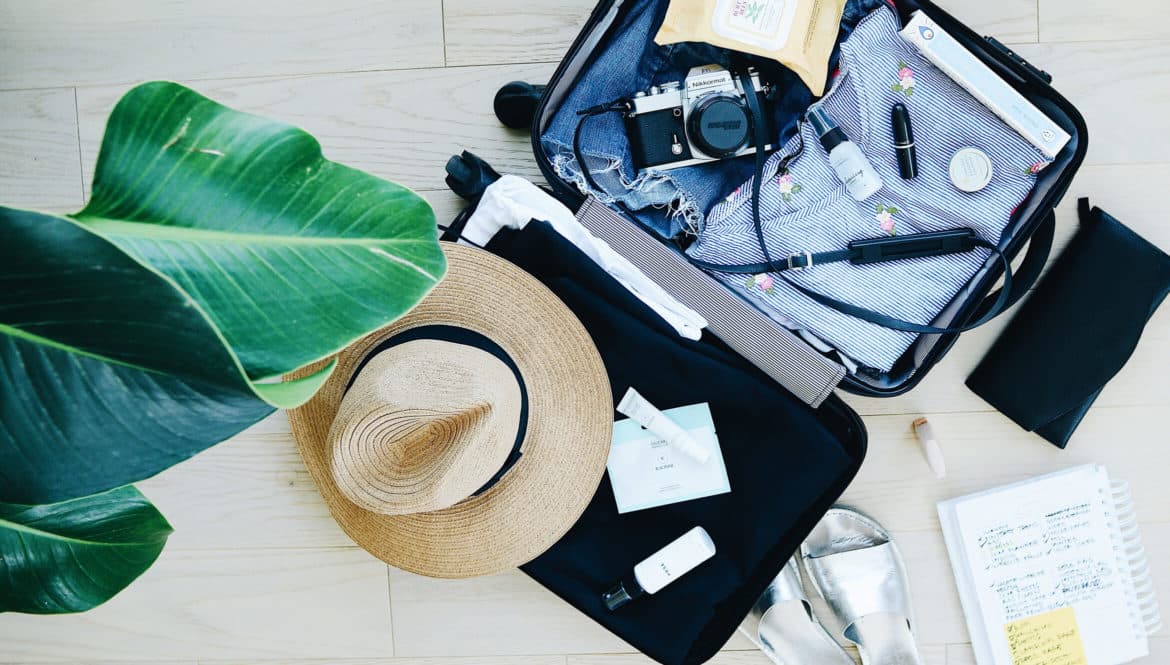 an open suitcase with a hat and other items.