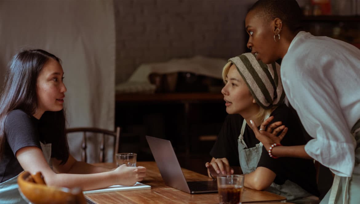 three girls talking at a coworking space