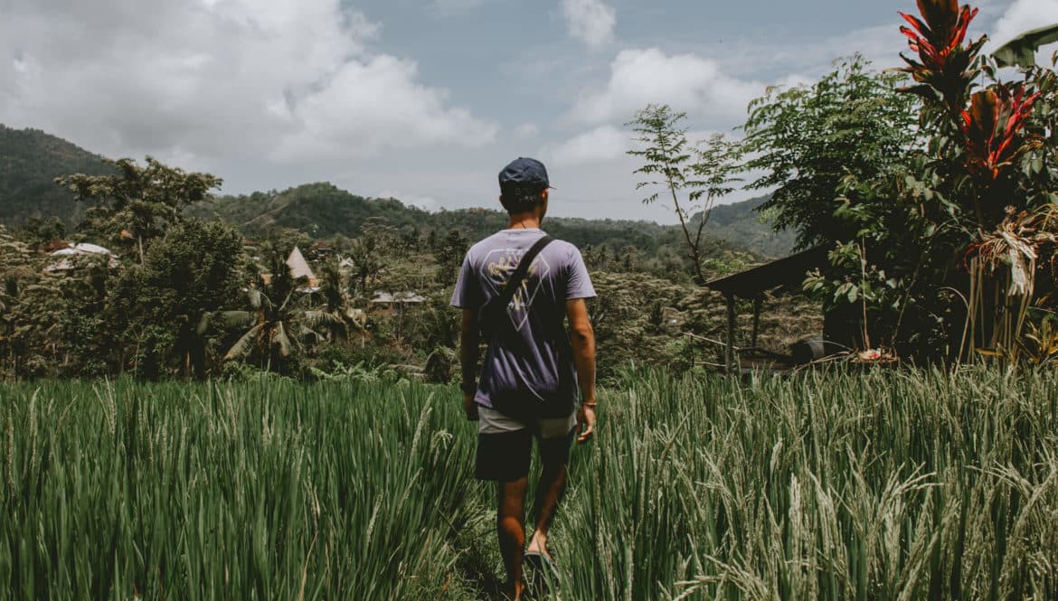 man walking through rice patties in Bali