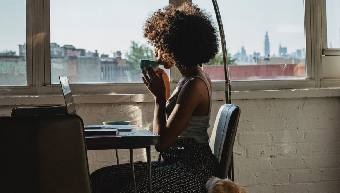 woman drinking tea as she works remotely