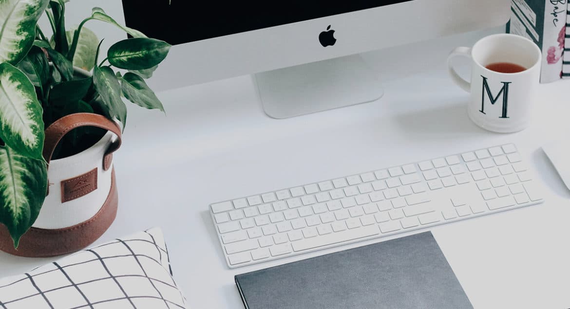 A morning routine that includes a desk with a computer, keyboard, mouse and a potted plant.