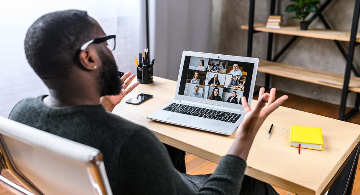 a man sitting in front of a laptop computer.