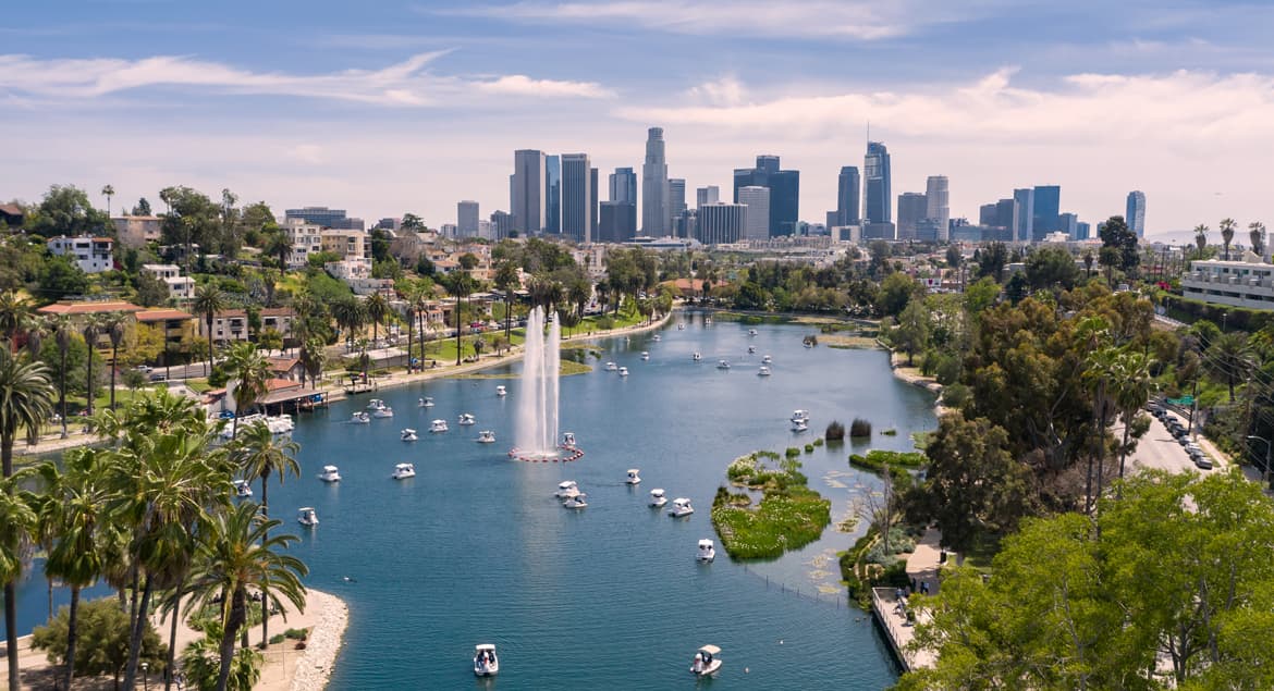 a view of a lake with boats in it and a city in the background.