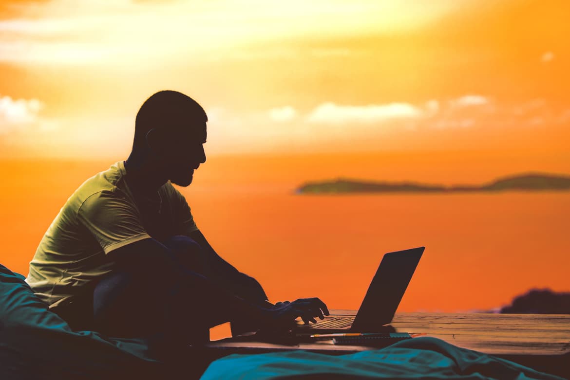 a man working on a laptop computer while receiving a stipend.