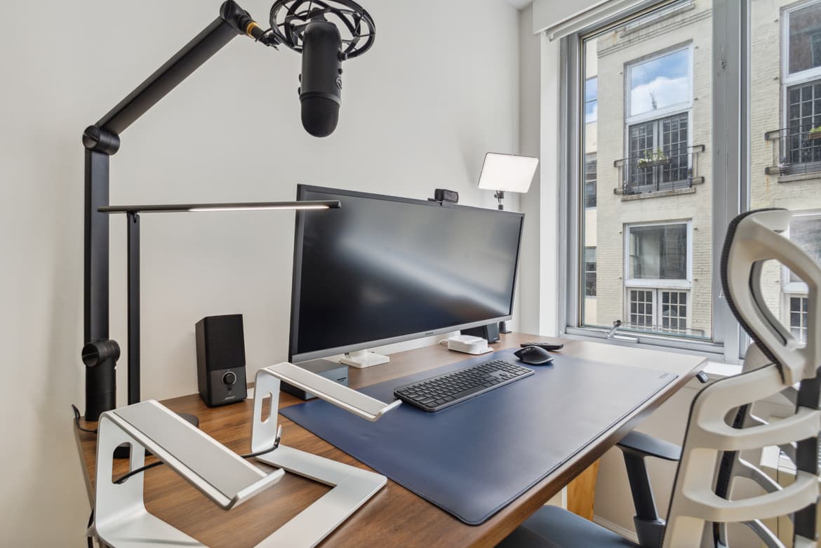 A workspace with a computer monitor, keyboard and mouse on a desk.